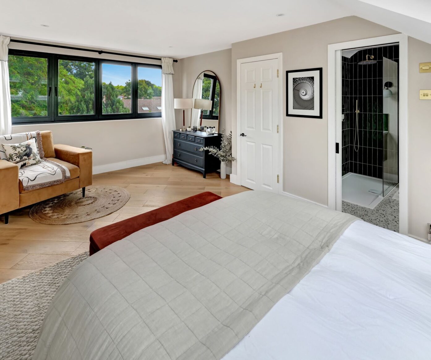 Large master bedroom with seating area, large windows and access to en-suite in a Walthamstow loft conversion