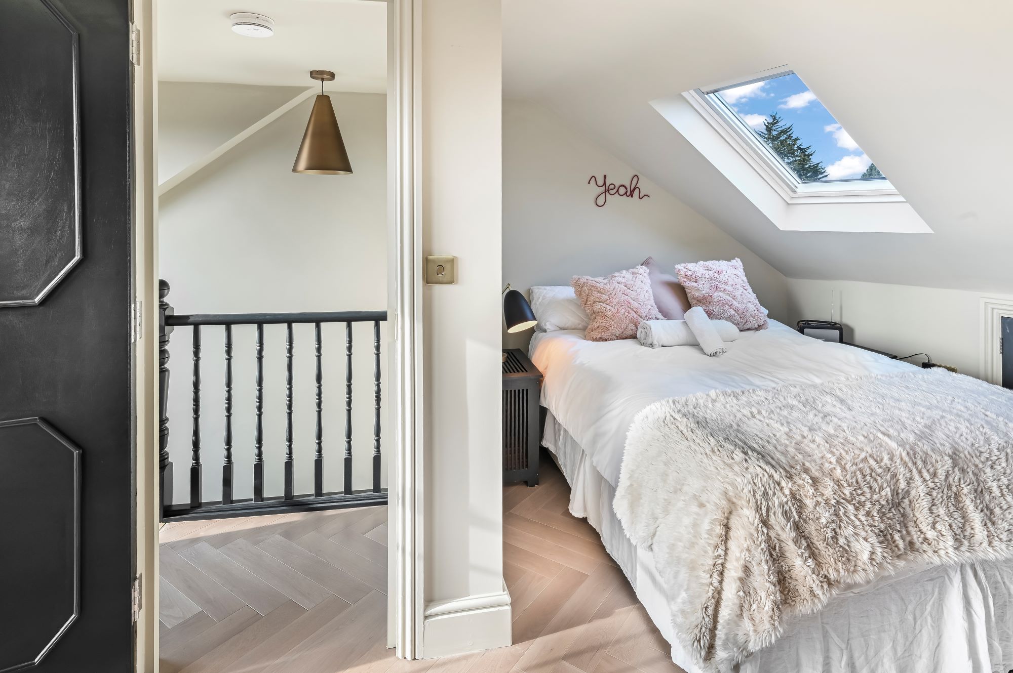 Cosy loft bedroom in Stanmore HA7 with a rooflight, soft furnishings and landing access