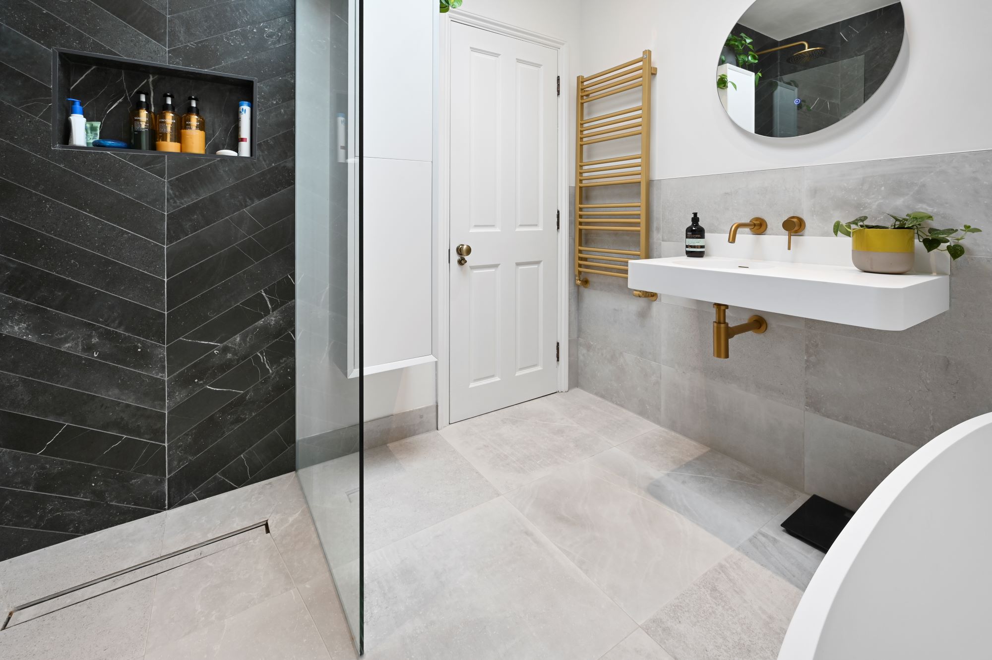 Modern loft conversion bathroom in Stanmore HA7 with walk in shower, brass fittings and grey tiles