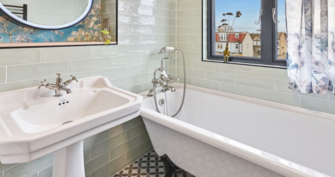 Traditional bathroom in a Stanmore HA7 loft conversion with freestanding bath and patterned floor tiles