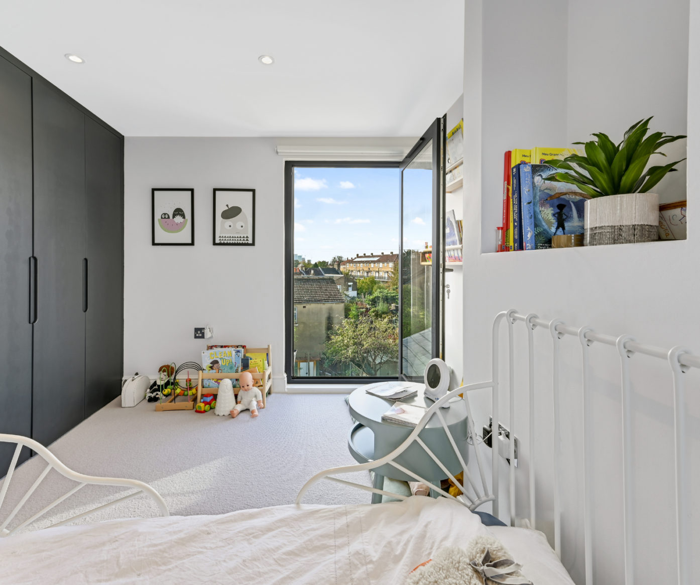 Loft conversion children’s bedroom with fitted storage, open glazed door and bright natural light for an Epping CM16 home.