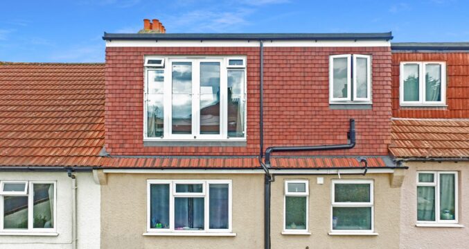 Rear dormer loft conversion exterior with red tiles and French doors for an Epping CM16 style property.