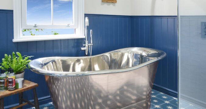 Loft conversion bathroom with feature bath and blue wall panelling for the Loughton Our Work page.