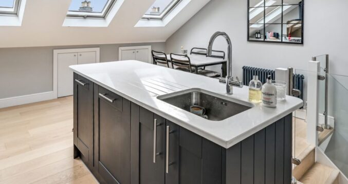 Loft kitchen space with island unit, rooflights and dining area, supporting the Palmers Green N13 Our Work page.