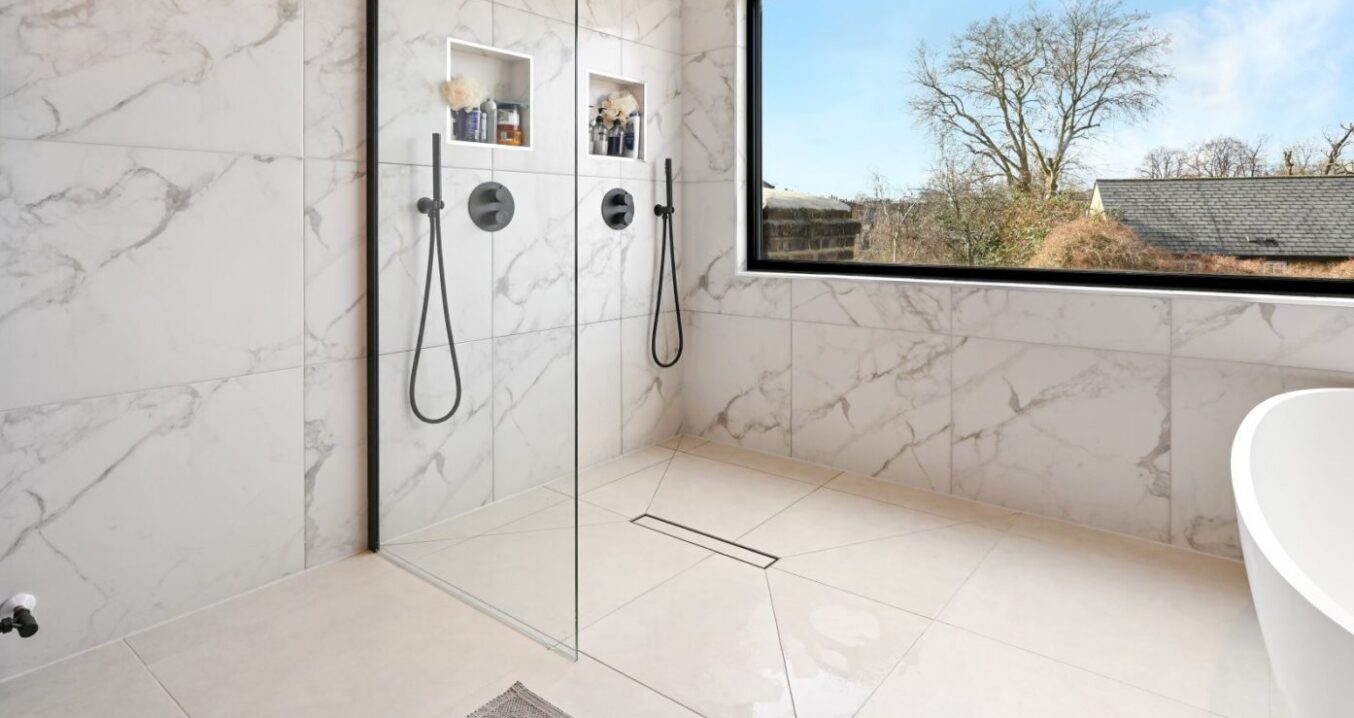 Luxury loft bathroom with large walk-in shower, marble effect wall tiles and picture window in Palmers Green N13.