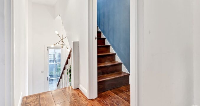 Loft staircase and landing with timber flooring and a bright lower hallway, used as layout inspiration for Palmers Green homes.