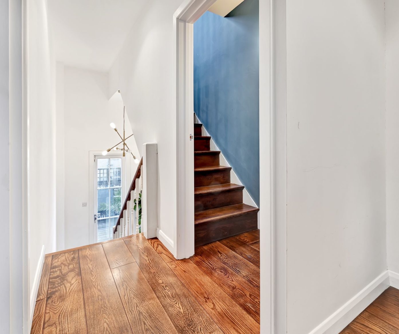 Loft staircase and landing with timber flooring and a bright lower hallway, used as layout inspiration for Palmers Green homes.