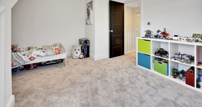 Children’s loft bedroom with storage, carpet and play space created in an Edgware HA8 loft conversion.