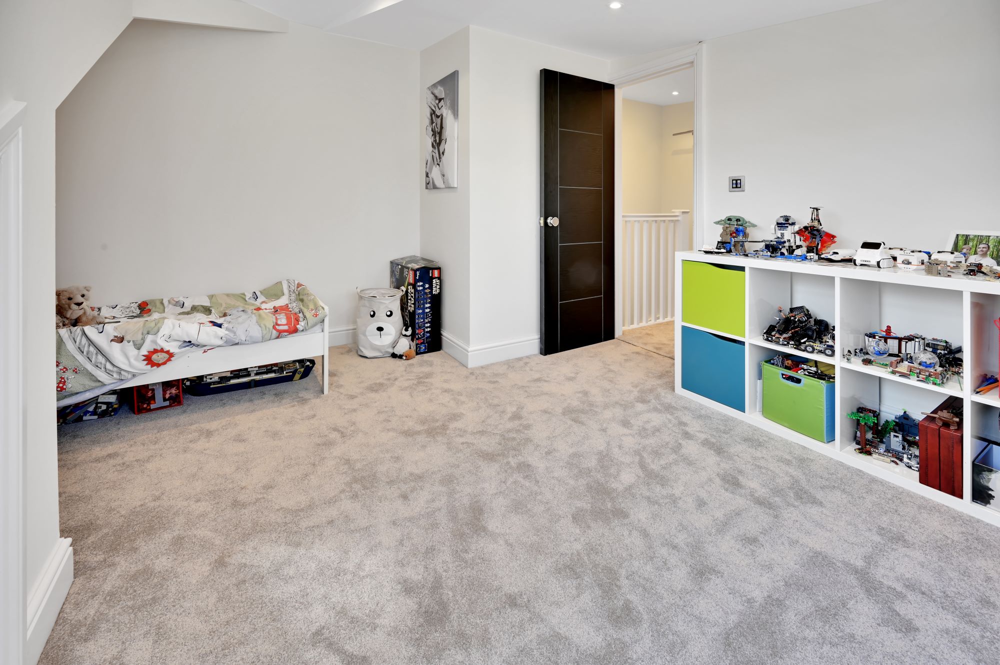 Children’s loft bedroom with storage, carpet and play space created in an Edgware HA8 loft conversion.
