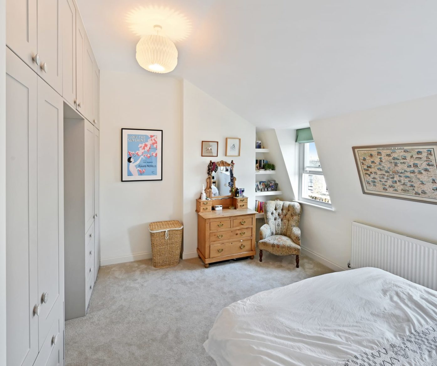 Loft bedroom with built-in wardrobes, bed, chair, window and neutral finish, supporting Crystal Palace loft conversion bedroom content.