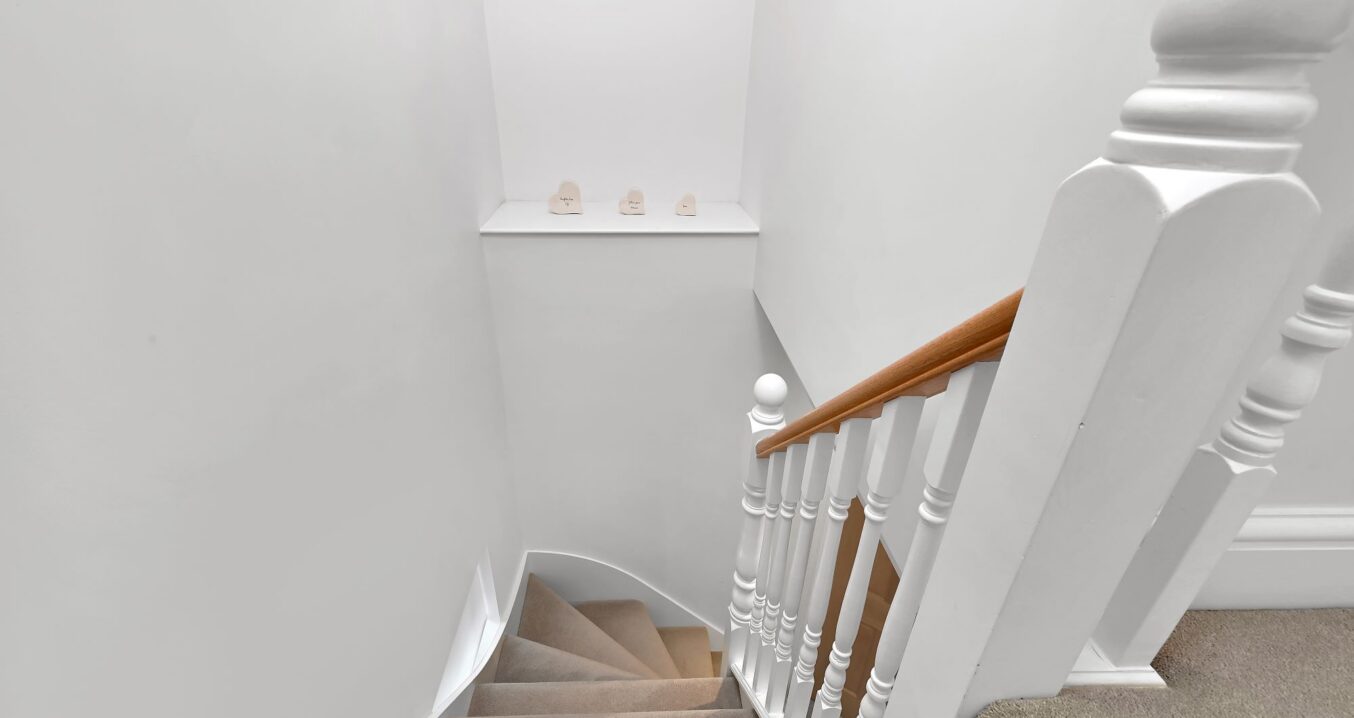 New loft staircase and landing with white balustrade and carpeted stairs in an Edgware HA8 loft conversion.