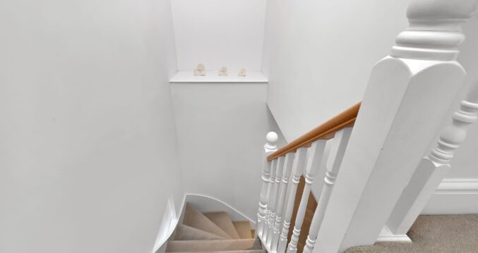 New loft staircase and landing with white balustrade and carpeted stairs in an Edgware HA8 loft conversion.