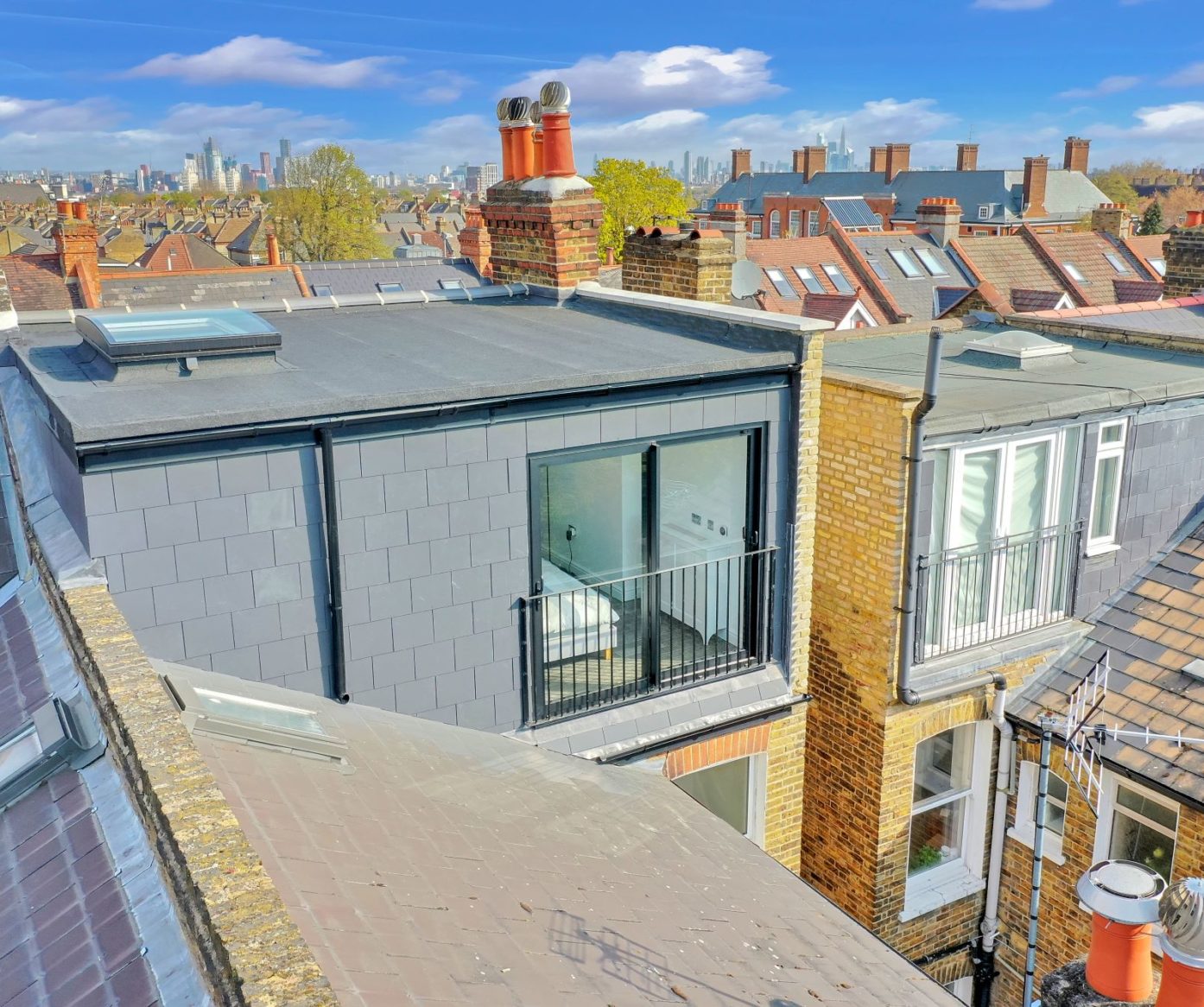 Rear loft exterior with French doors, grey cladding, roof-level view and neighbouring roofs, supporting Crystal Palace loft conversion content.