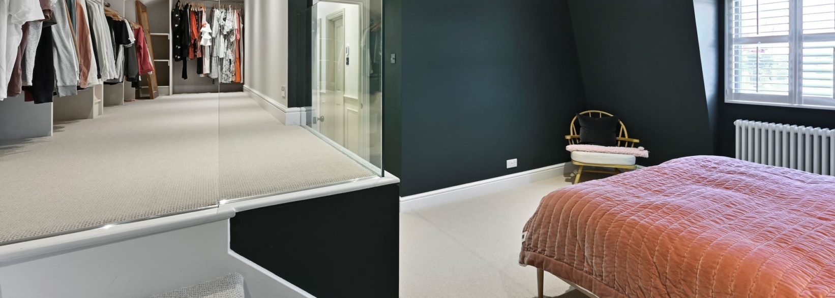 Spacious loft conversion bedroom with walk-in wardrobe, glass balustrade and staircase, featured on the Billericay CM12 Our Work page