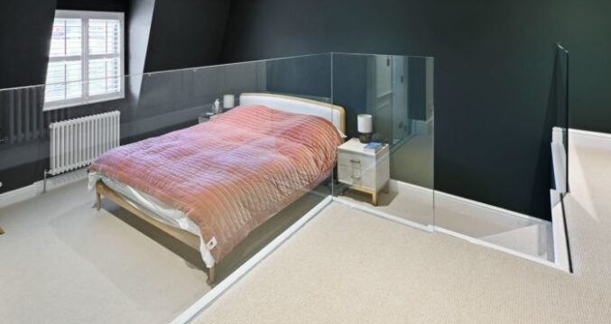 Finished loft conversion bedroom with dark feature walls, staircase and glass balustrade, featured on the Billericay CM12 loft conversion page