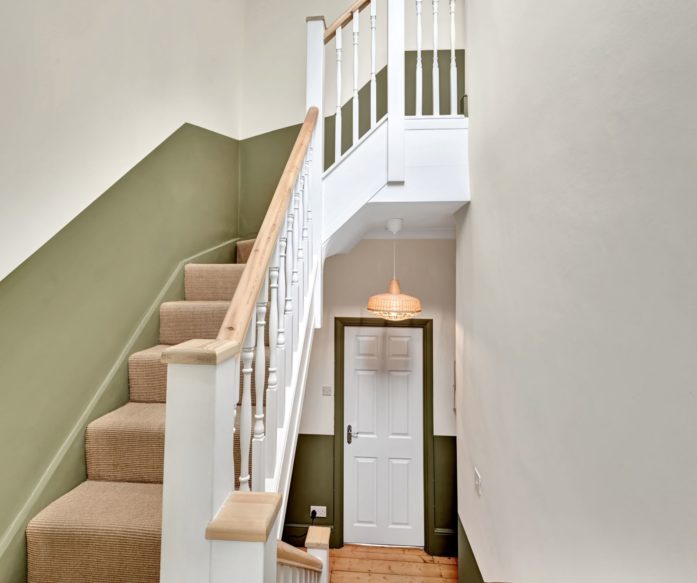 Spacious loft living room with rooflights, grey carpet and a seating area in a Winchmore Hill N21 loft conversion