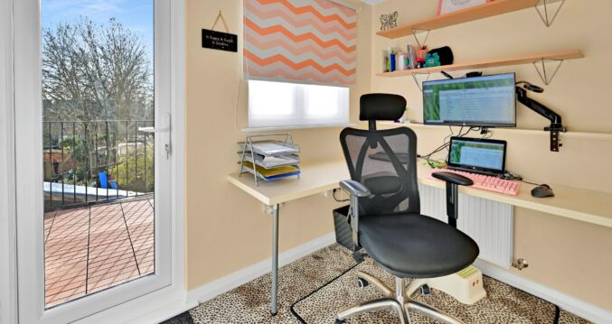Loft home office with fitted desks, storage and a glazed door leading to a balcony in Winchmore Hill N21