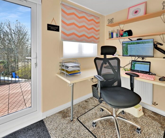 Loft home office with fitted desks, storage and a glazed door leading to a balcony in Winchmore Hill N21
