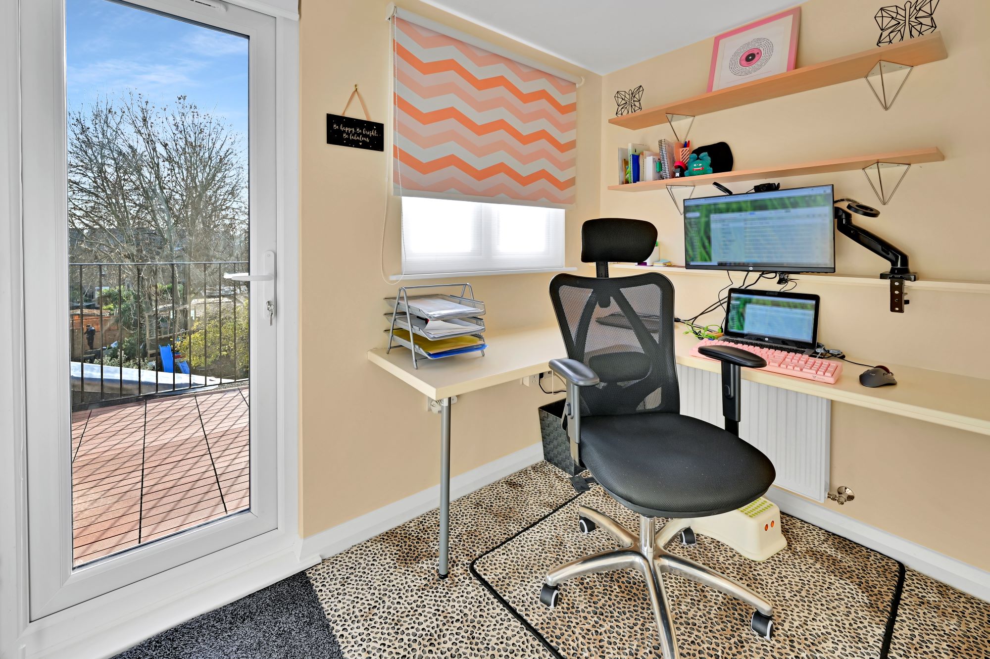 Loft home office with fitted desks, storage and a glazed door leading to a balcony in Winchmore Hill N21