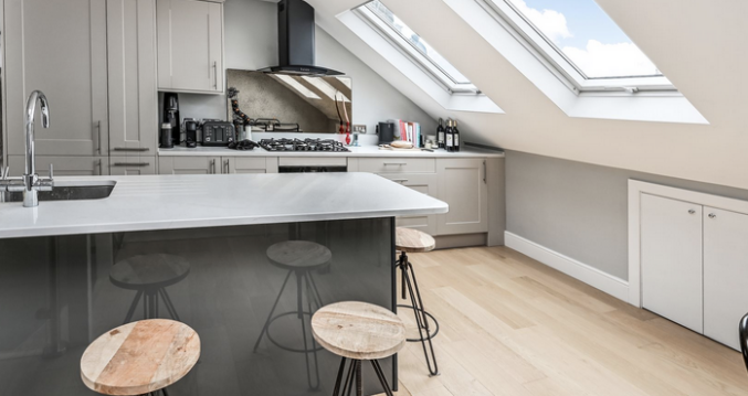 Contemporary loft kitchen with island seating, fitted units and three rooflights in a Winchmore Hill N21 conversion