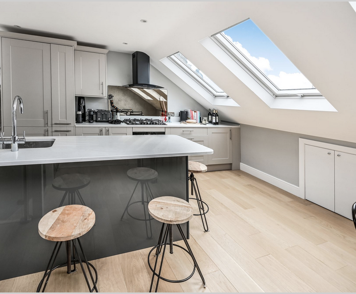 Contemporary loft kitchen with island seating, fitted units and three rooflights in a Winchmore Hill N21 conversion