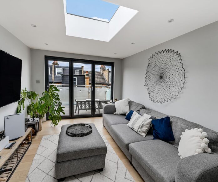 Modern loft living space with a roof dome, glazed doors and access to a balcony in Winchmore Hill N21