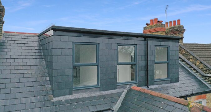 Rear dormer exterior with dark slate cladding, three windows and traditional surrounding roof finishes for the Wood Green N22 loft conversion page.